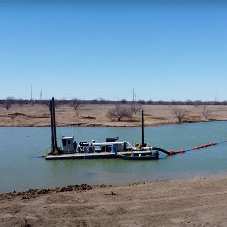 dredging boat in water in canal